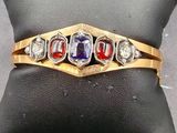 un gros plan d'une bague posée sur un oreiller, elle-même posé sur un autre oreiller
