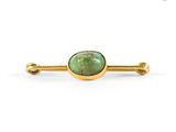 a close up of a green stone broochle on a white background