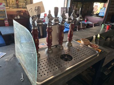 several beer taps are lined up on a metal counter in a bar