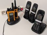 five cell phones and a charger on a table