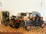 deux voitures miniatures d'un ancien modèle posées côte à côte sur une table