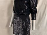 un mannequin portant une robe noire à une épaule et un haut noir