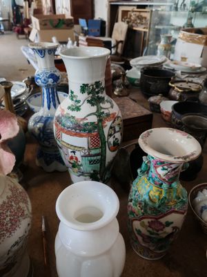 de nombreux vases et bols posés sur la table dans la pièce