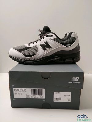 Les chaussures New Balance sont dans la boîte posée sur la table.