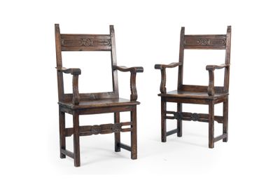pair of antique wooden chairs with carved arms on white background