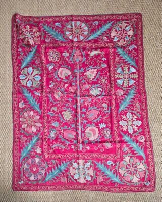 un gros plan sur un tapis rose orné de fleurs et de feuilles
