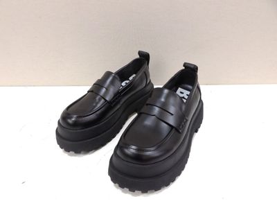 des chaussures à semelles compensées noires avec des semelles noires sur un fond blanc