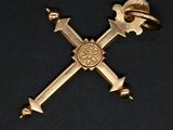 a gold cross with a crown on top of it on a black background