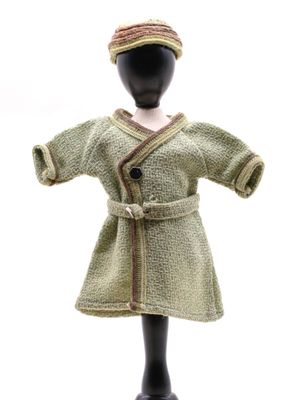 un mannequin vêtu d'un manteau vert et d'un chapeau