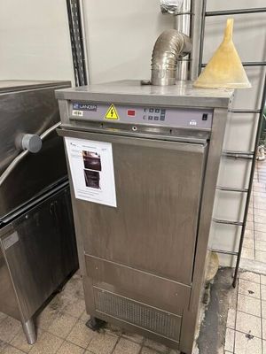 un lave-vaisselle en acier inoxydable installé dans une cuisine, à côté d'une cuisinière