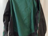 leather jacket hanging on a wall with a white curtain behind it