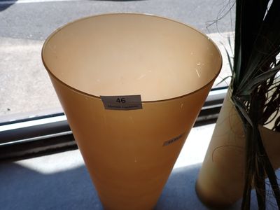 un vase posé sur une table près d'une fenêtre