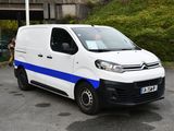 a white van with blue stripes parked in a parking lot
