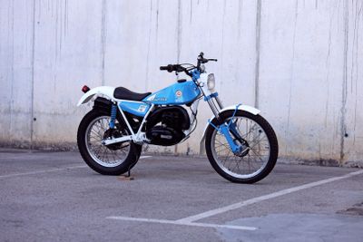 une moto bleue et blanche garée sur un parking