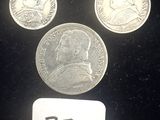 trois pièces d'argent posées les unes à côté des autres sur une surface noire