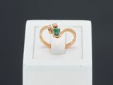 gros plan d'une bague en or avec une pierre verte