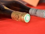 two bottles of wine sitting on a red cloth