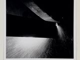 a black and white photo of a person cutting a piece of paper