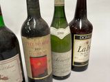 several bottles of wine are lined up on a white surface