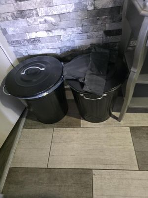 deux poubelles posées l'une à côté de l'autre sur le sol