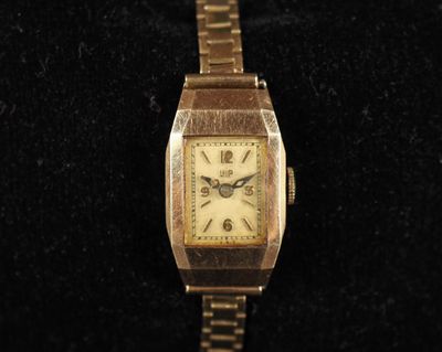 une image montrant un gros plan d'une montre en or posée sur une surface noire