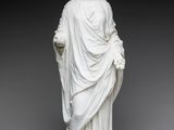une statue en marbre blanc représentant une femme tenant une fleur