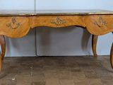 a wooden table with a marble top on a brick floor
