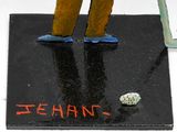 a figurine of a man standing on a black surface