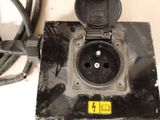 a black electrical outlet with a yellow sticker on it