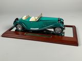 a model of a green car on a wooden stand