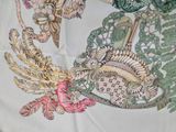 a close up of a table cloth with a bird on it