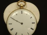 une petite horloge blanche avec des chiffres romains