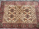 a red and beige rug on a grey floor