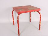 an old red metal stool with a red top on a white surface