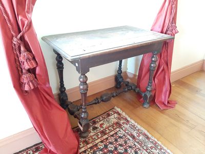 une petite table recouverte de rideaux rouges dans une pièce