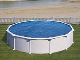 une piscine au milieu d'une pelouse, avec un pont en arrière-plan