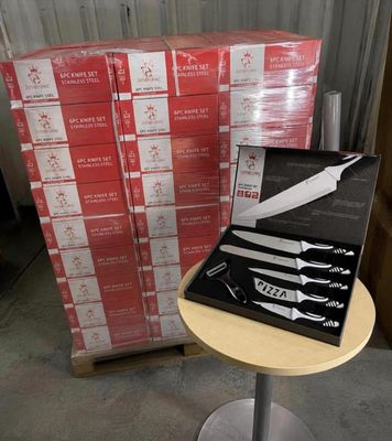 a box of knives on a table next to a stack of boxes