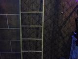 a ladder in the corner of a room with a purple light