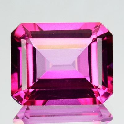 un gros plan d'une pierre précieuse rose sur une surface blanche