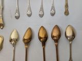an assortment of silver and gold spoons and spoons on a table