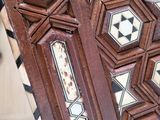 a close up view of a wooden table with a tile design on it