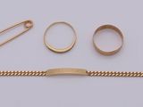 a close up of a gold bracelet, a ring, a pin, and a chain