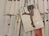 a lot of magazines on a table with a woman ' s legs on them