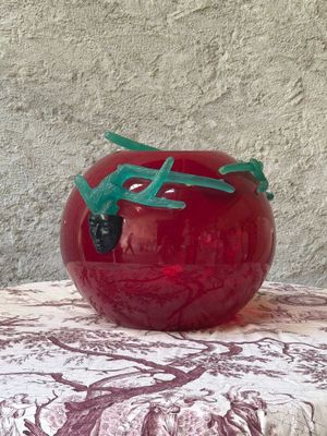 a red vase with a green dragon on it on a table