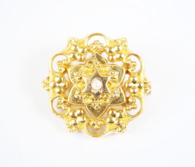 a close up of a gold brooch with pearls on it