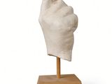statue of a hand with a thumb up on a wooden base