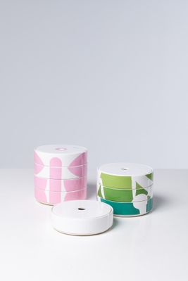 trois rouleaux de ruban posés sur une table, sur fond blanc