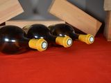 three bottles of wine sit on a red cloth next to a wooden box