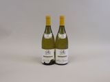 deux bouteilles de vin blanc posées l'une à côté de l'autre sur une surface blanche