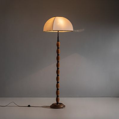 un lampadaire en bois surmonté d'un abat-jour blanc